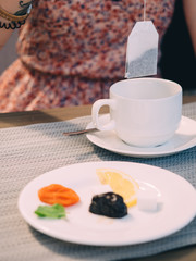 Tea bag over cup in cafe on wooden table