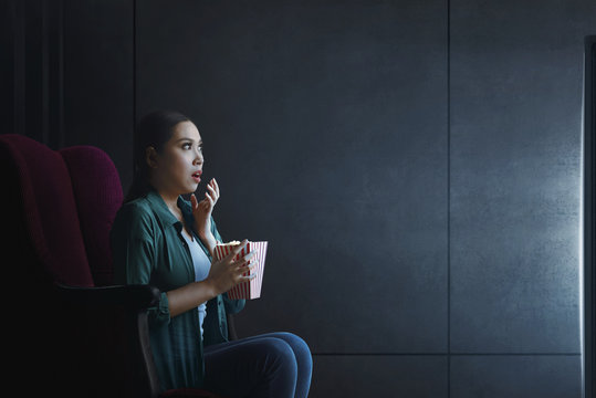 Portrait Of Asian Woman With Popcorn Watching Horror Movie