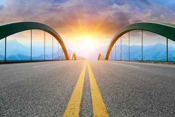 Asphalt highway and mountain landscape at sunset