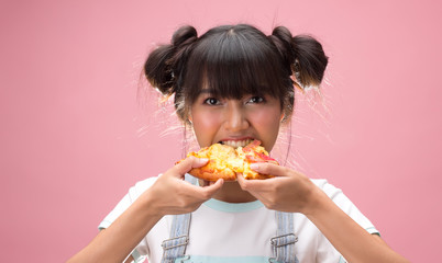 Happy young asian woman eating slice of pizza