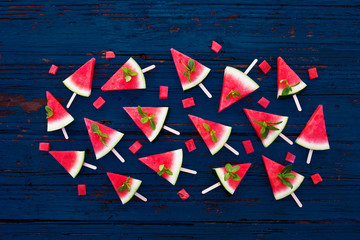 Fresh Watermelon  sliced popsicles on  blue rustic wooden background. Flat lay. Tropical Summer concept .