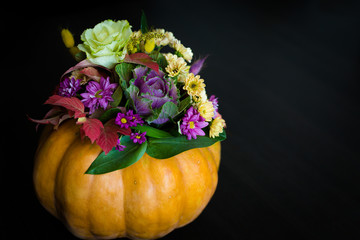 Autumn flowers arrangement in a pumpkin