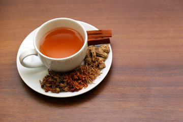 Brewed healthy herbal tea on a wooden background with all dry herbs ingredients. Herbal teas beverage for chinese or thai traditional alternative medicine therapy. 