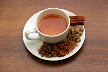 Brewed healthy herbal tea on a wooden background with all dry herbs ingredients. Herbal teas beverage for chinese or thai traditional alternative medicine therapy. 