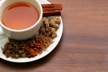 Brewed healthy herbal tea on a wooden background with all dry herbs ingredients. Herbal teas beverage for chinese or thai traditional alternative medicine therapy. 