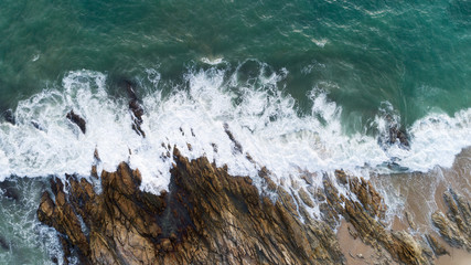 Aerial view drone shot of seascape scenic off beach in phuket thailand with wave crashing on the rocks.