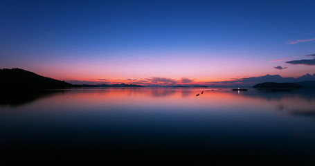 Fototapeta premium Long exposure image of Dramatic color sky seascape with reflection in sunset or sunrise scenery nature for background.