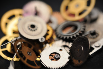 Detail of watch machinery in spoon on the brown wood background.