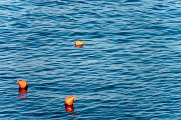 Three Orange Mooring Buoys on the Sea