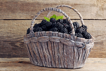 Fototapeta na wymiar Ripe blackberries in basket on wooden table