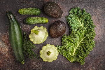 Assortment of green vegetables on a dark background, top view. Fruits and vegetables containing...
