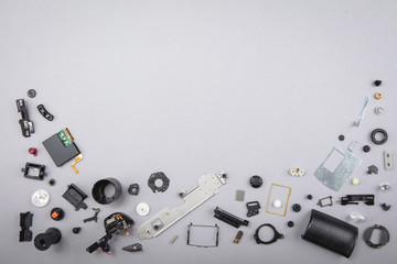 Different parts with a photo camera on a gray background.
