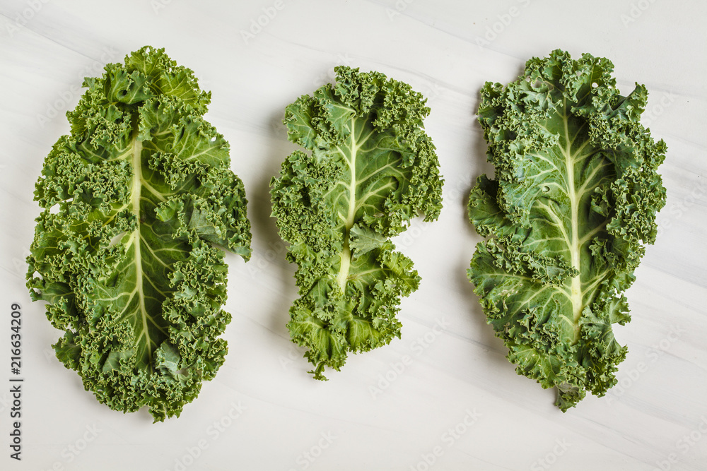 Wall mural Leaves of kale on a white background. Top view, copy space.