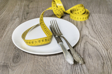 Weight Loss and Diet Concept with Empty Plate with Measuring Tape
