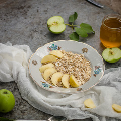 porridge - a portion a breakfast of oat flakes with honey, apples. food background