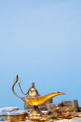 Magic lamp of wishes on stacks of gold coins. Studio shooting.