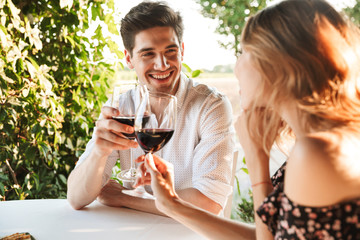 Loving couple sitting in cafe by dating drinking wine
