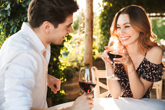 Loving Couple Sitting In Cafe By Dating Drinking Wine