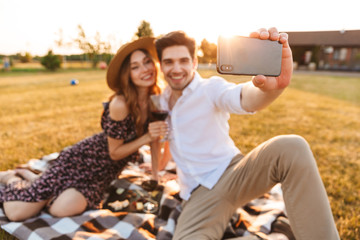 Young cute loving couple take a selfie by mobile phone.