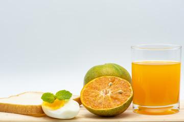 Orange juice in glass with heathy foods on wood table