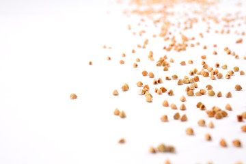 Buckwheat grain scattered over white background