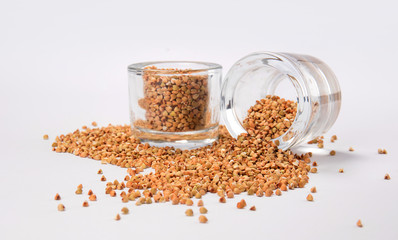 top view of a scattered seeds near in a glass jar on a white background