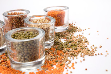 top view of a different beans and seeds near in a glass jar on a white background