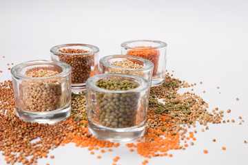 top view of a different beans and seeds near in a glass jar on a white background