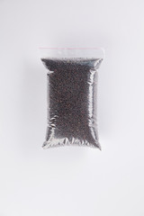 Flat lay view of rape grains in transparent package on white background.