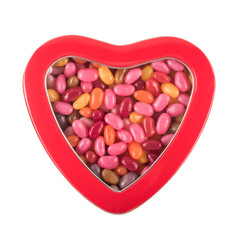 Heart-shaped box with multicolor candies isolated over white