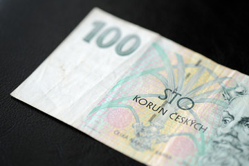 A banknote in one hundred Czech crown on a dark background close up