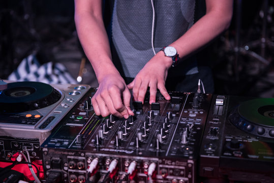 Dj mixes the track in the nightclub at party, hand playing music at turntable on party