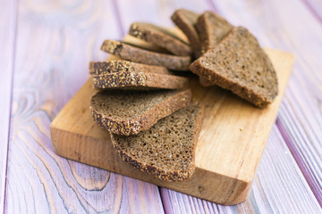 Slices of black bread on a wooden background.