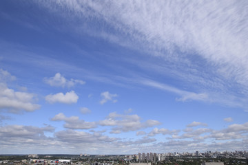 Blue sky with clouds and city in the background
