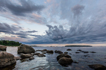 Fototapeta na wymiar Rocks and sky reflecting in calm sea waters at shore