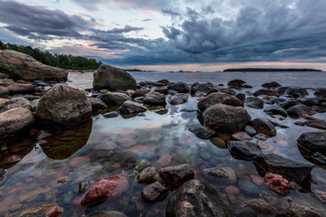 Rocks and sky reflecting in calm sea waters at shore