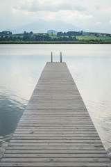 Obraz premium Steg am See in den Bergen am Tag mit Wolken im Sommer