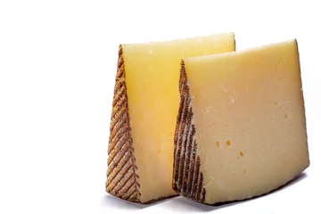Fototapete Two pieces of Manchego, queso manchego, cheese made in La Mancha region of Spain from the milk of sheep of the manchega breed, isolated on white © barmalini