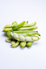 New harvest of healthy vegetables, green fresh raw big broad beans close up isolated on white background