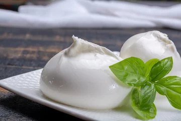 Fototapeten Fresh soft white burrata, ball buttery cheese, made from a mix of mozzarella and ricotta cream, original from Apulia region, Italy, very popular soft cheese in USA © barmalini