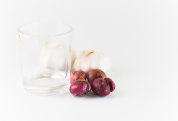 empty glass with garlics and onions isolated on white background.