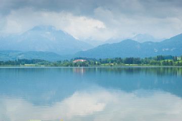 Wolken über dem Hopfensee in den Alpen im Allgäu