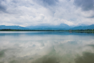 Wolken über dem Hopfensee in den Alpen im Allgäu
