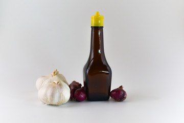 empty seasoning glass bottle with garlic and onion isolated on white background. selective focus.