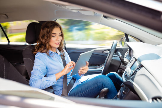 Young woman using tablet in a self-driving car