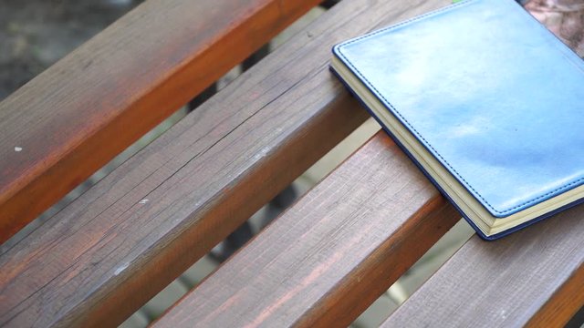 Notebook on bench in park, business concept