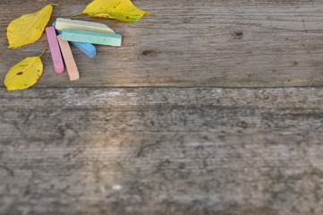 Naklejka na ściany i meble colorful school crayons and yellow leaves on wooden background. rustic. September 1st.