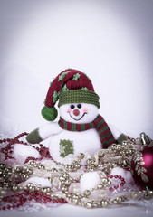 cute toy snowman and various Christmas decorations on a white b