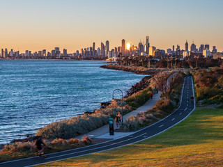 Obraz premium Runners and cyclists enjoying the sunset from Ormond point in Melbourne, Australia