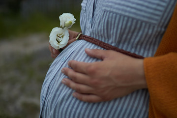 close-up of big pregnant belly woman in striped dress